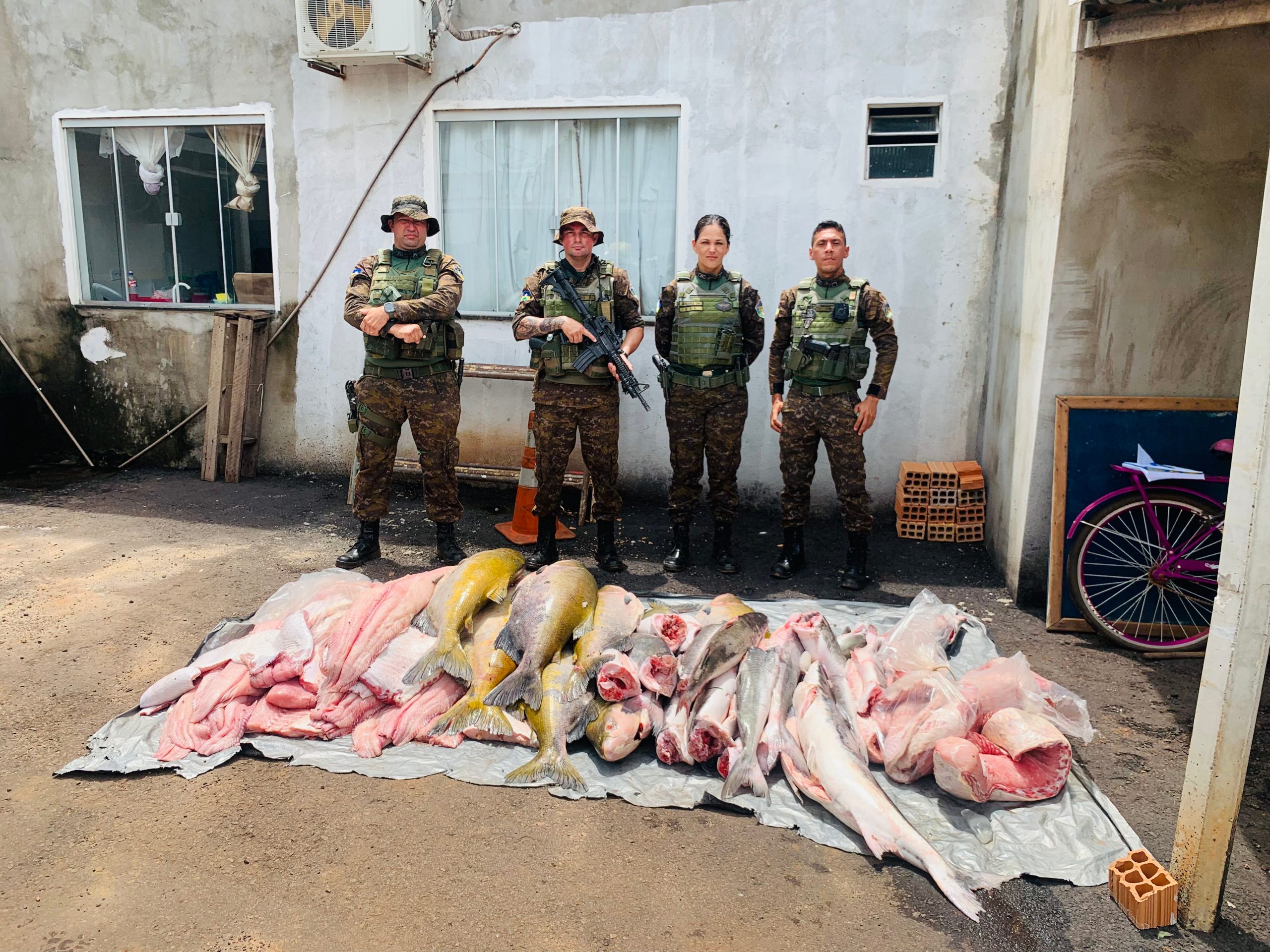 Policiais com o pescado apreendido.